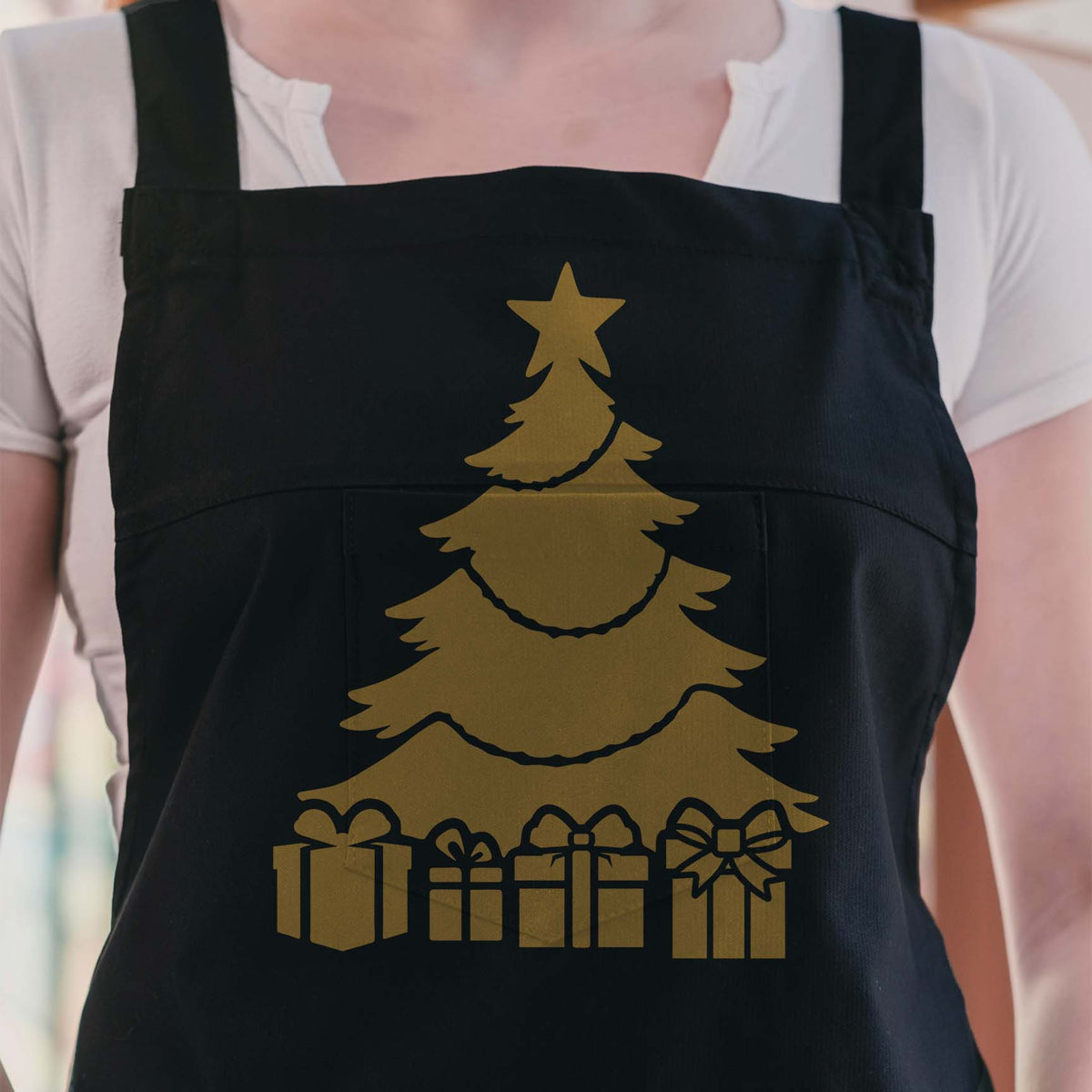 Black apron featuring the Christmas Tree with Presents Stencil in metallic gold.