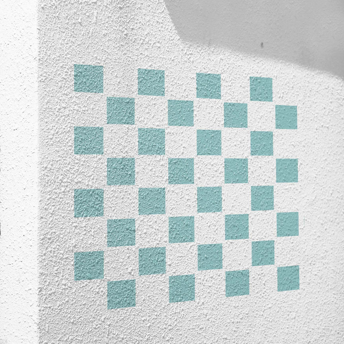 On a white stucco wall, Classic Checkerboard Pattern Stencil appears in soft mint squares.