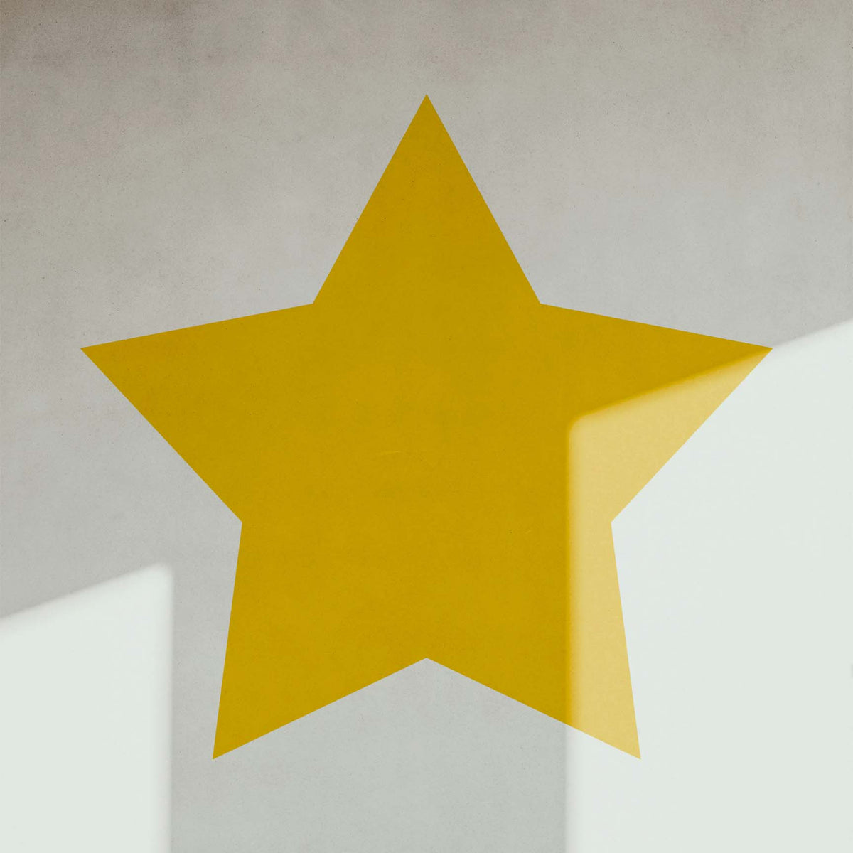 Bold and sunny, the Classic Five-Point Star Stencil stands out in golden yellow against a white wall.