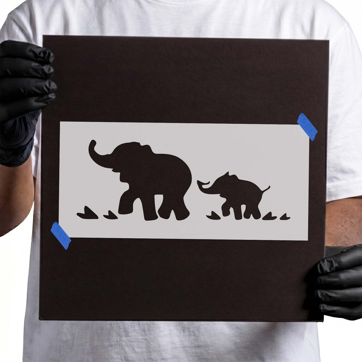Elephant stencil with large and small silhouettes walking with raised trunks
