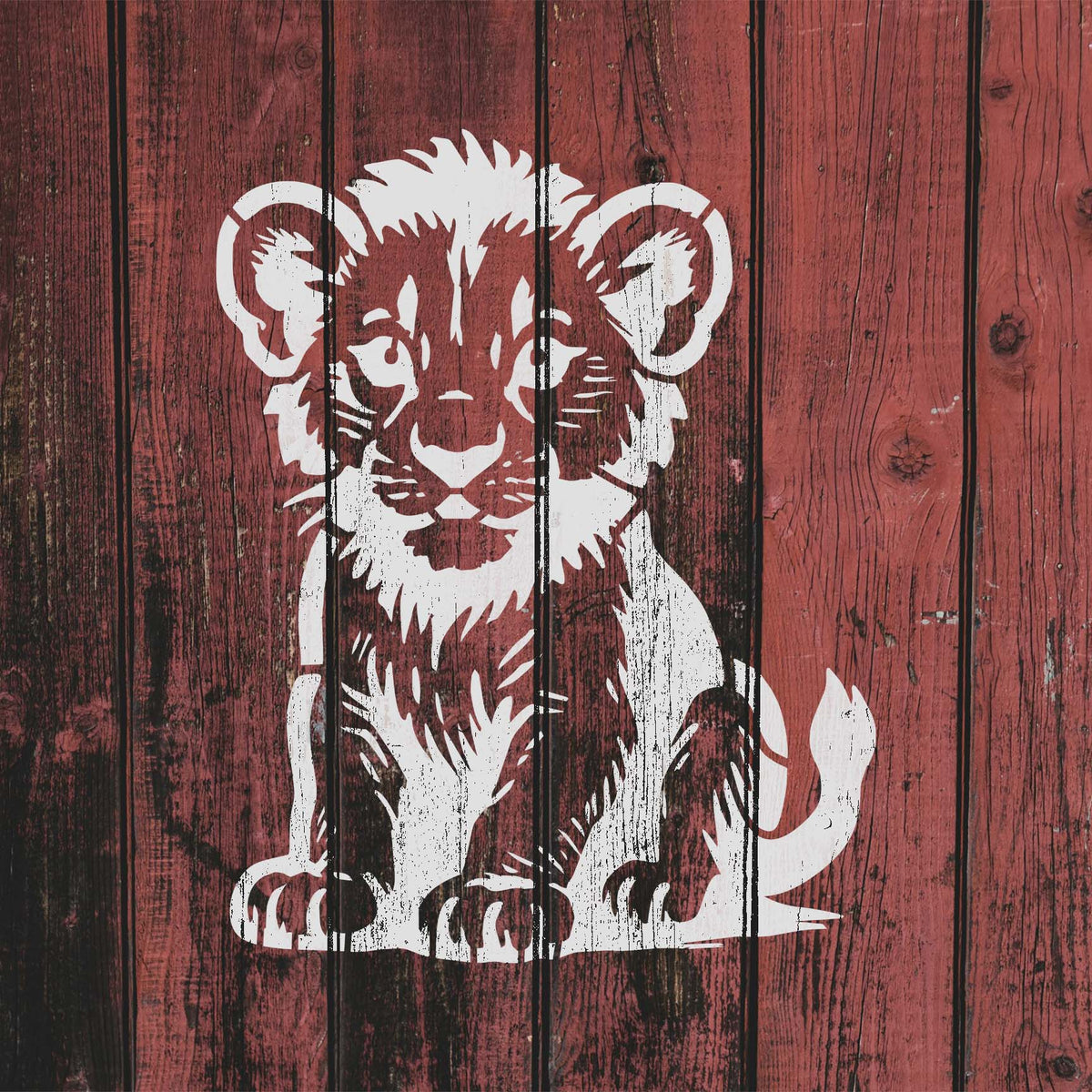 Rustic red wood features the Cute Lion Cub Stencil in white with detailed face and seated pose.