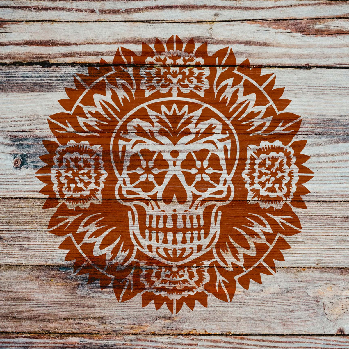 Rustic wood showcases the Day of the Dead Sugar Skull Mandala Stencil framed by ornate flowers