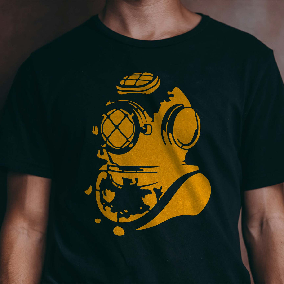 Golden Deep Sea Diver Helmet Stencil stands out across the front of a black T-shirt