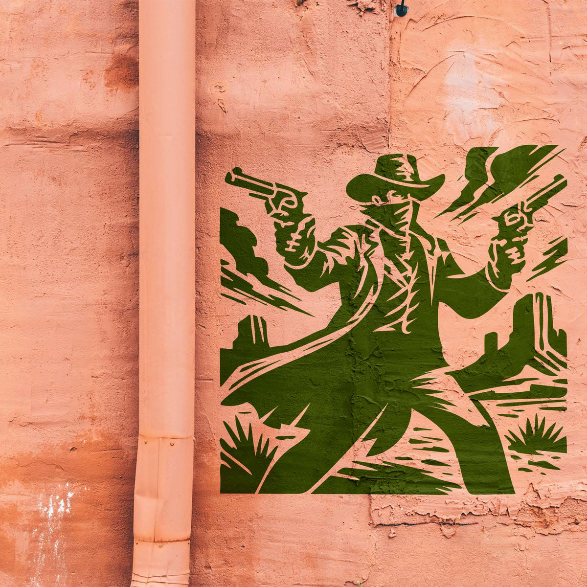 Desert Gunslinger Stencil painted in green on a peach stucco wall beside a vertical pipe.