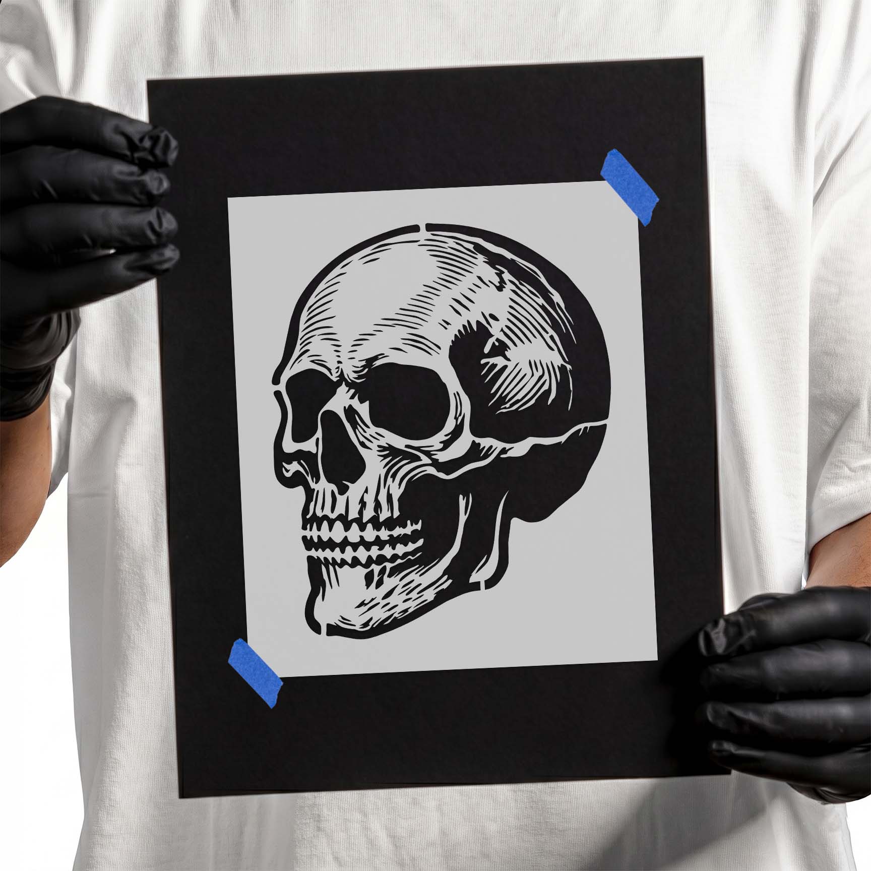 Person holding Detailed Anatomical Skull Stencil taped to cardboard