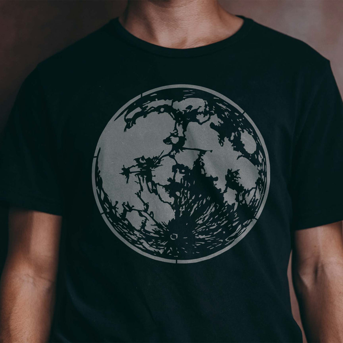 A cratered gray moon takes center stage on a black T-shirt with the Detailed Full Moon Stencil.