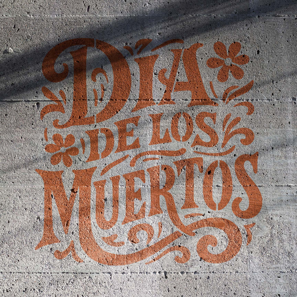 Ornate Día de los Muertos Lettering Stencil stands out with flowers and flourishes on concrete