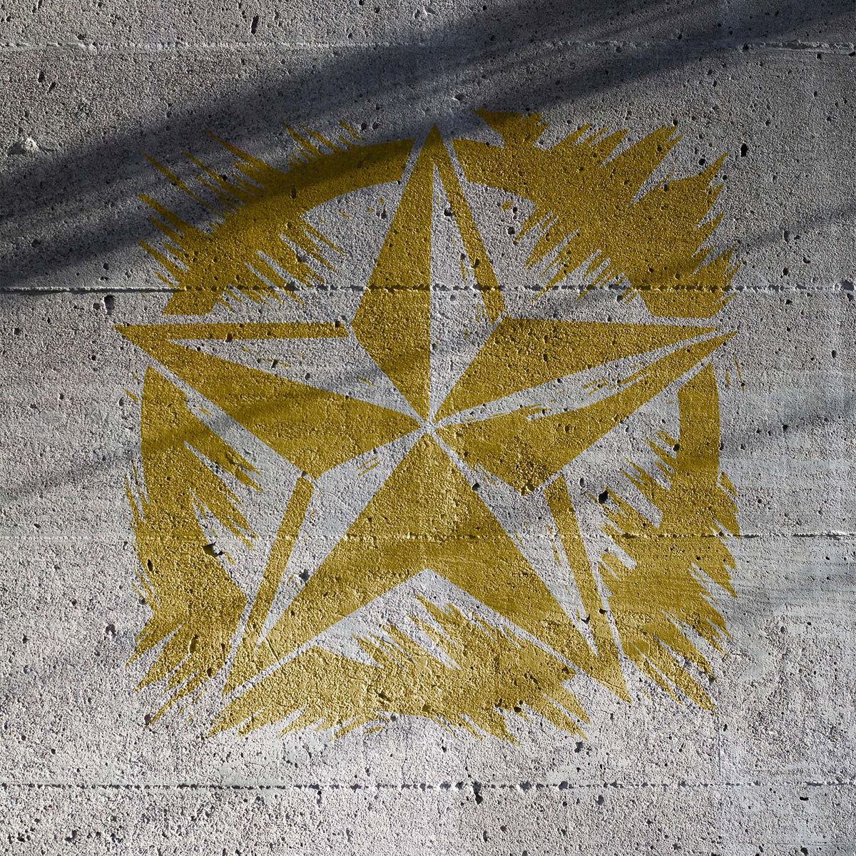 A worn Distressed Army Star Stencil stands out in gold across a textured concrete wall