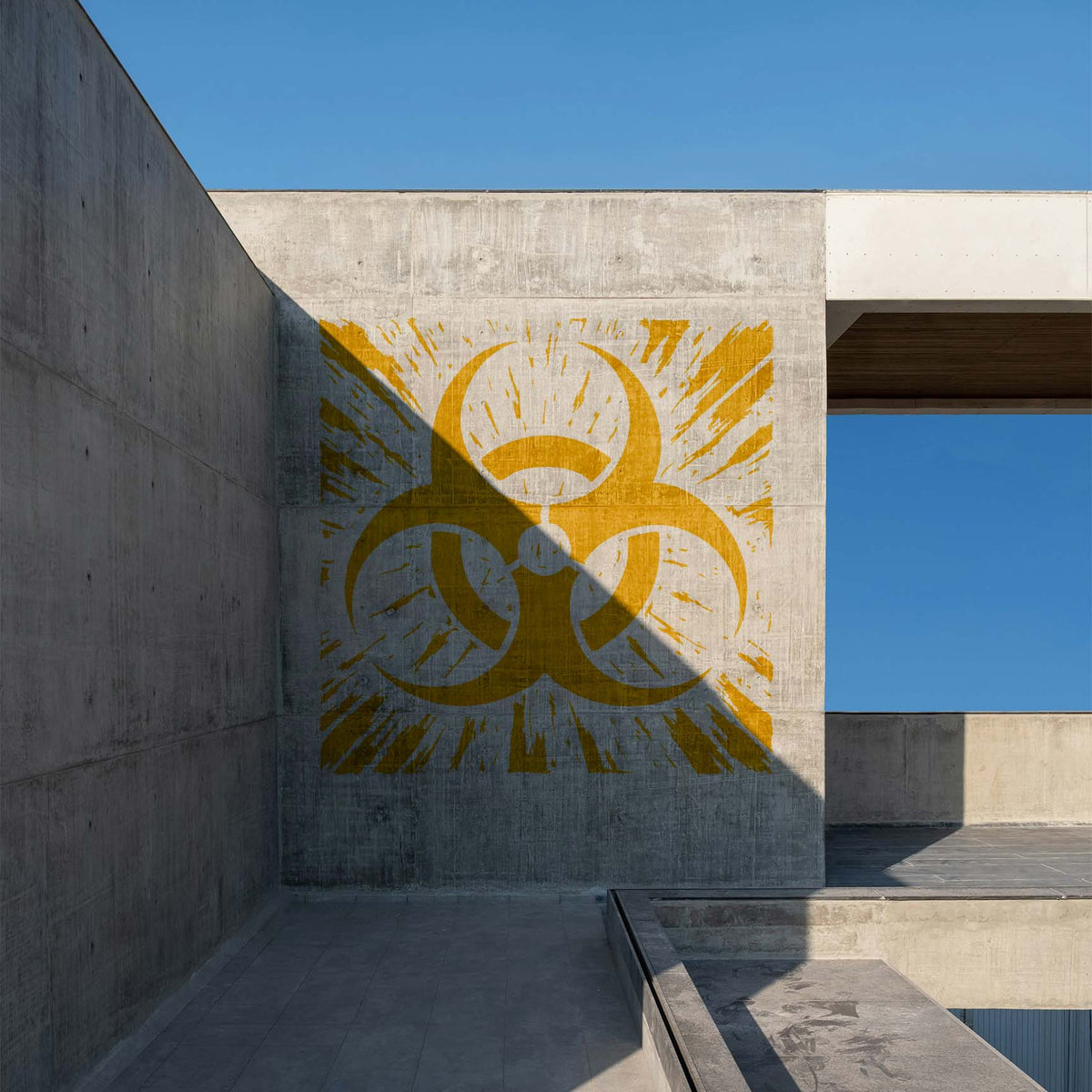 Across a modern concrete wall, the Distressed Biohazard Symbol Stencil appears in weathered yellow.
