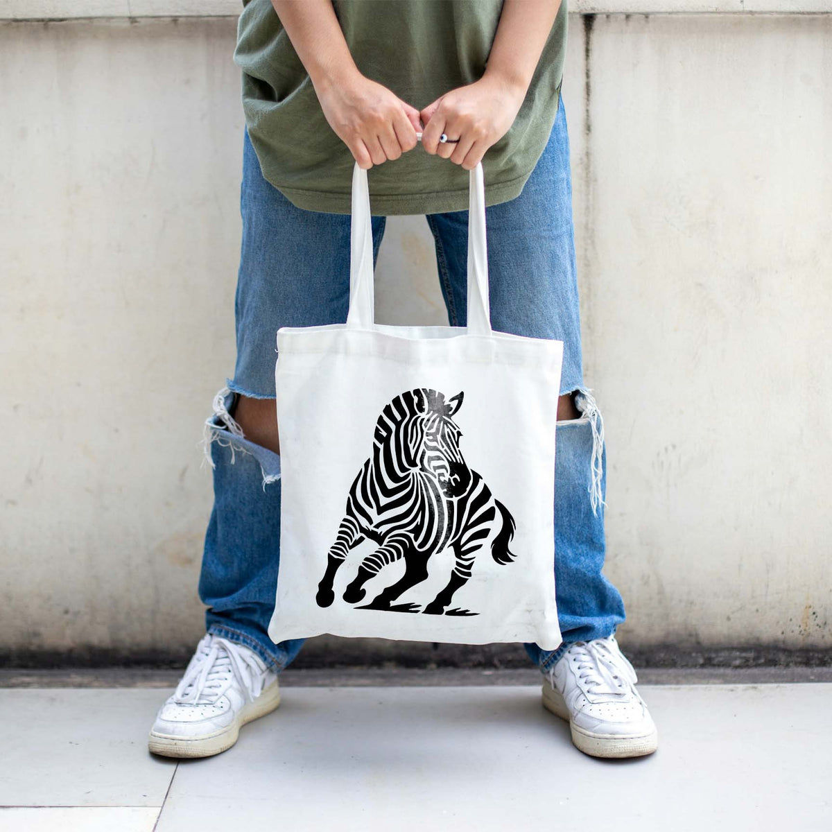 Bold running zebra stencil printed in black on a white canvas tote bag