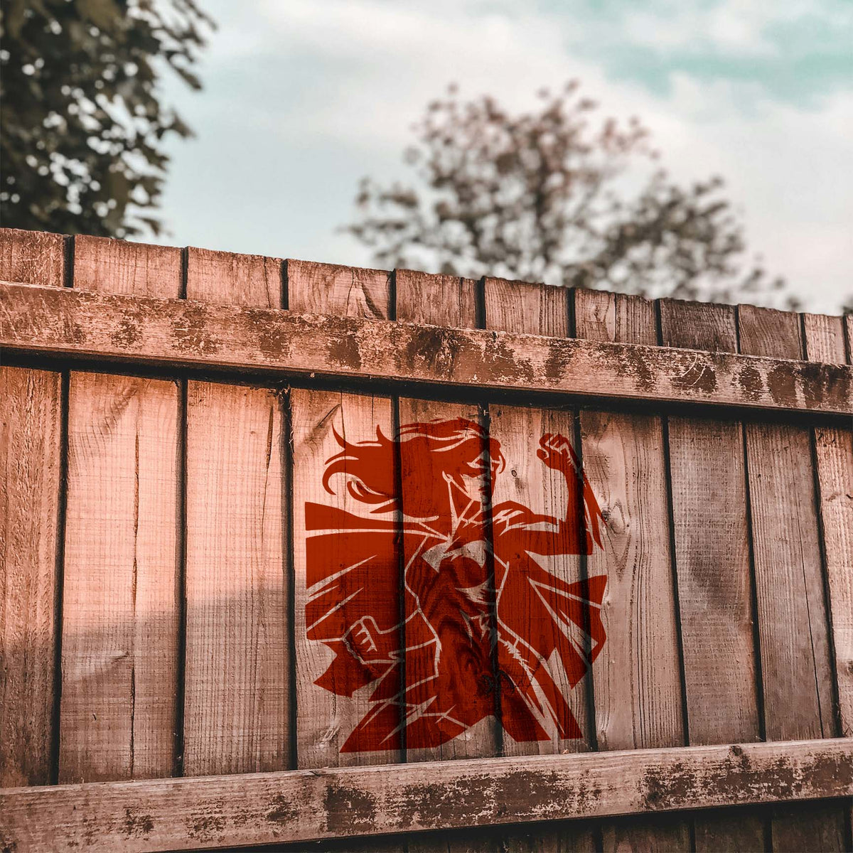 Empowered Female Superhero Stencil features a strong caped heroine painted on a wood fence
