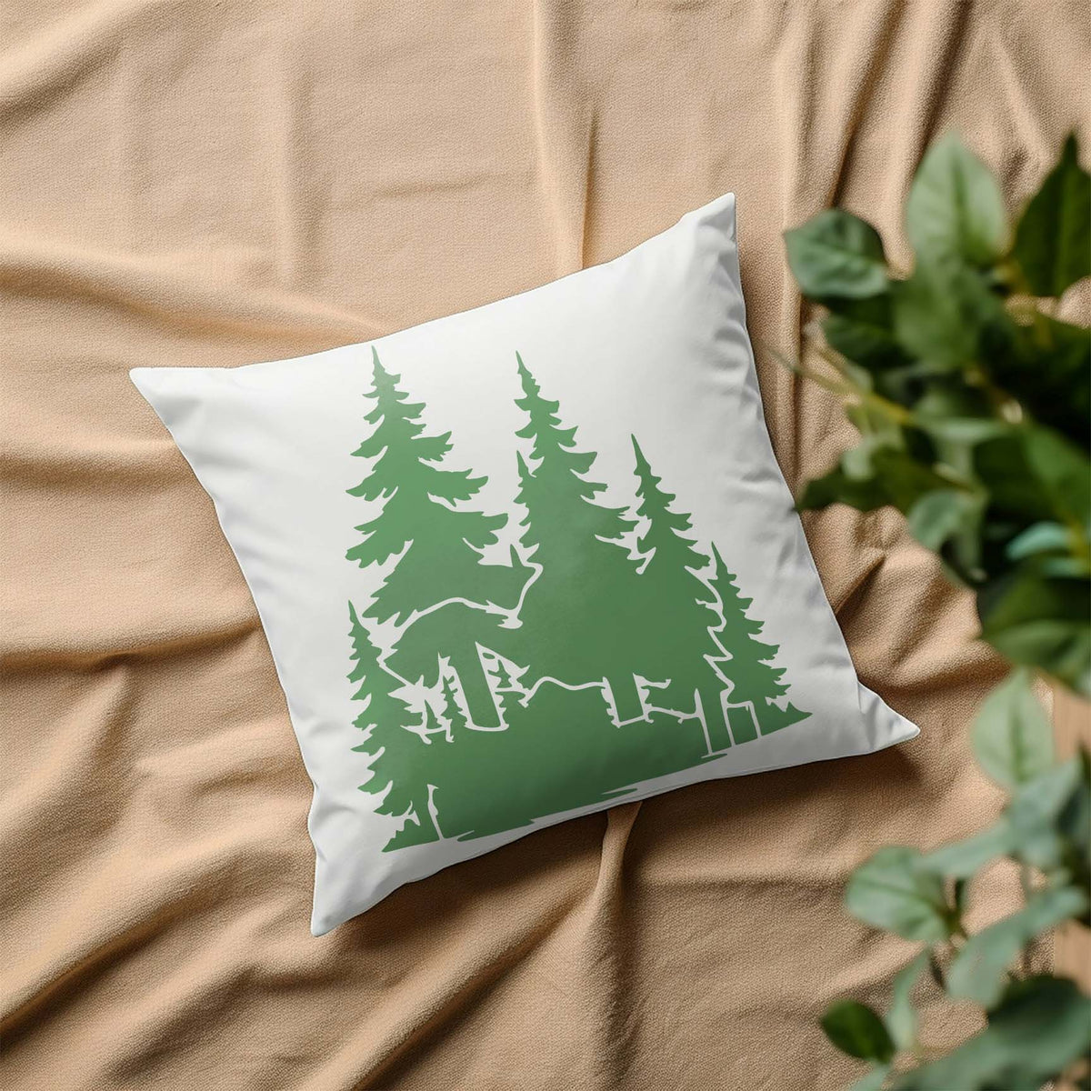 Soft green pine silhouettes from the Evergreen Woodland Trees Stencil decorate a white throw pillow.