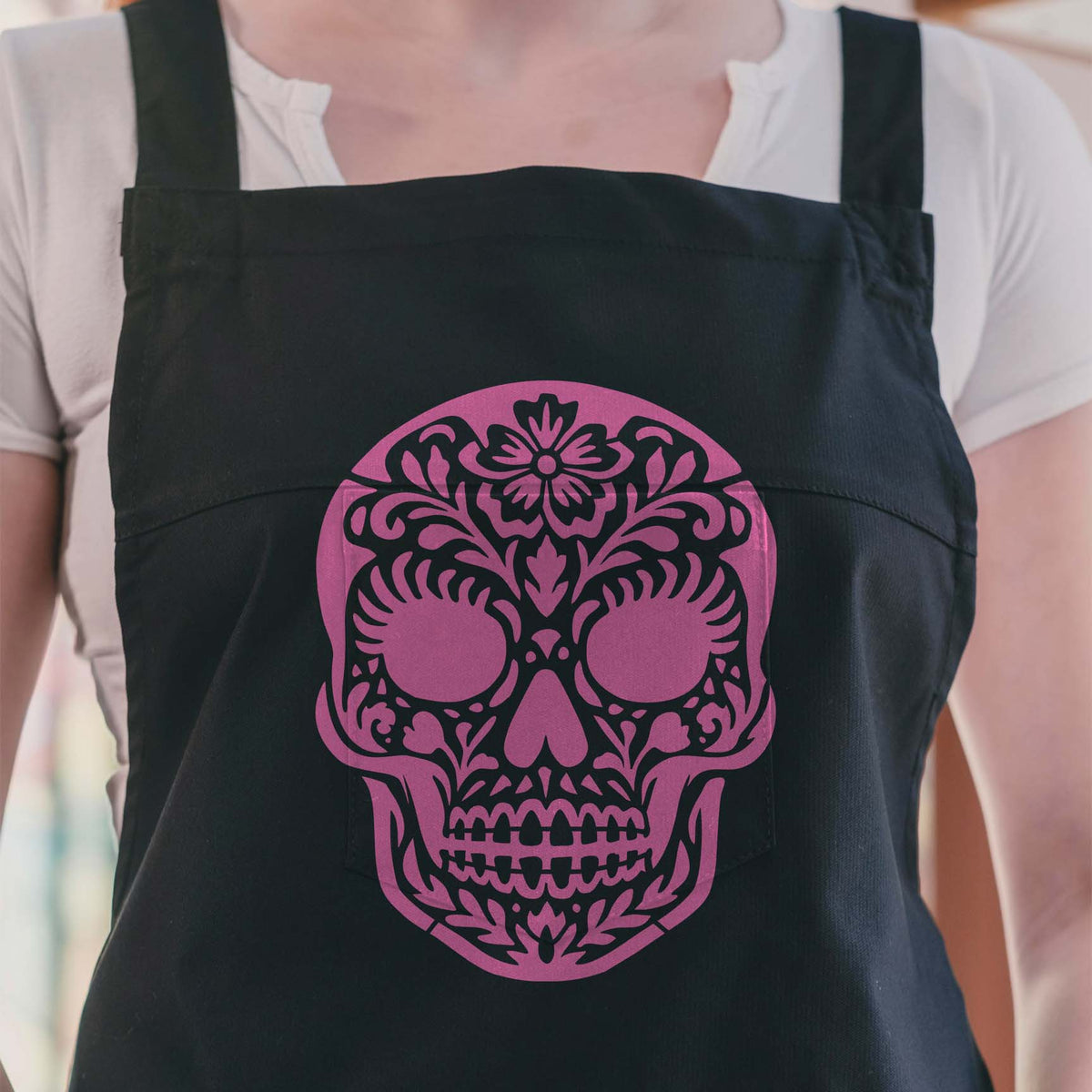 Pink Female Sugar Skull Stencil adds ornate floral details across a black apron