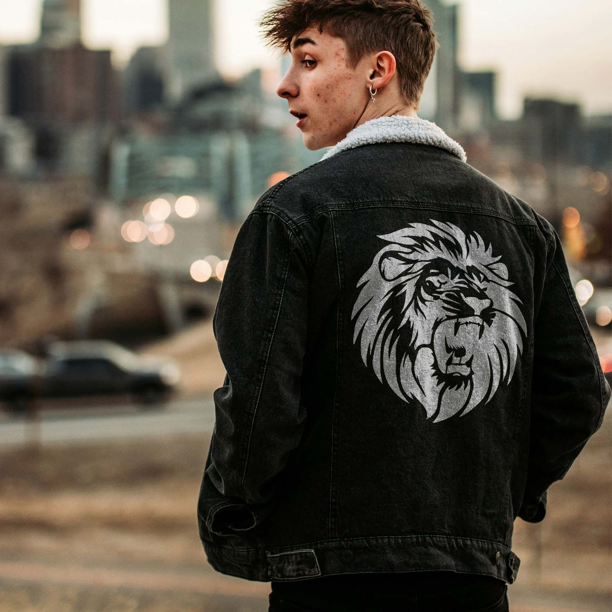 Silver Fierce Lion Portrait Stencil stands out boldly on the back of a black denim jacket.