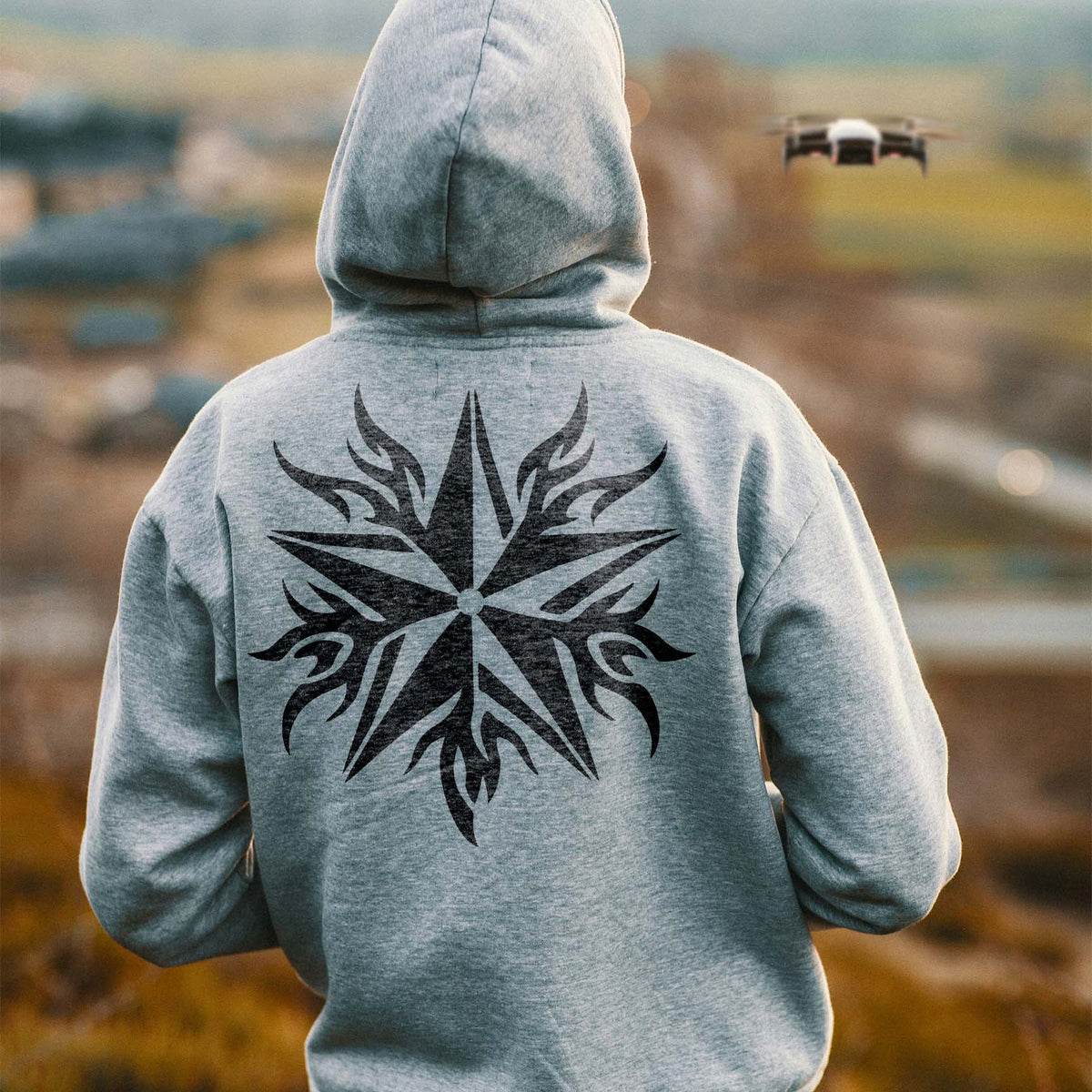 Across a gray hoodie, the Flame Tribal Star Stencil forms a striking black tribal motif