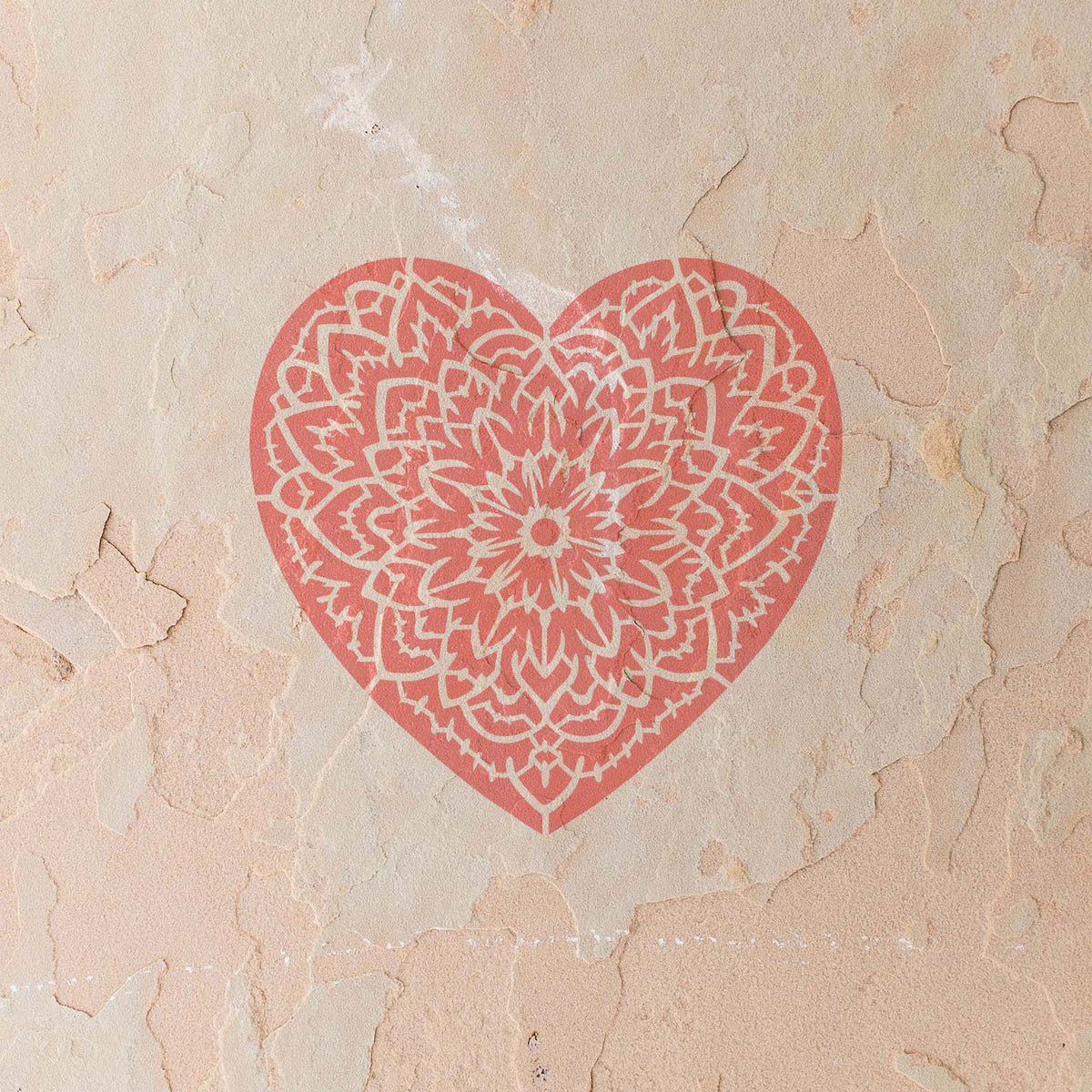 Coral Floral Mandala Heart Stencil adds an ornate floral pattern to a textured stucco wall