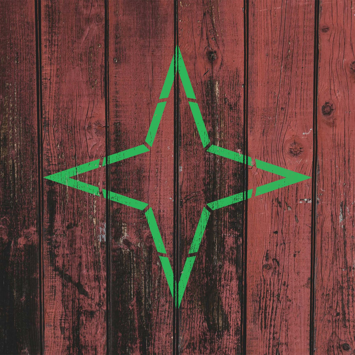 Weathered red wood showcases the Four Point Star Outline Stencil in a vivid green finish