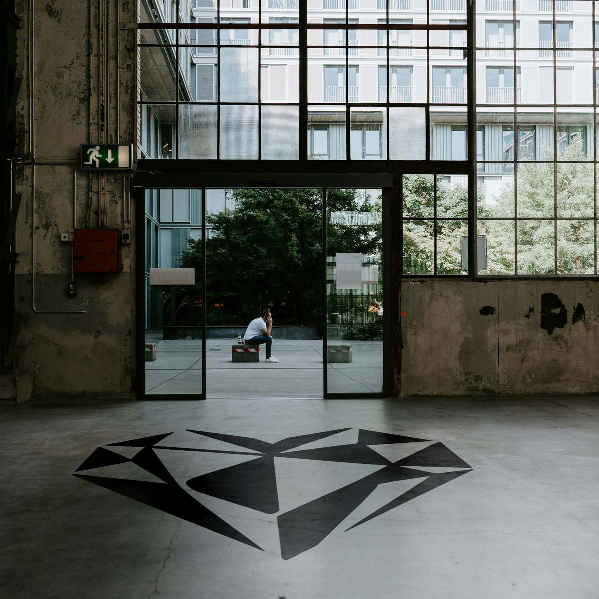 Geometric Heart Stencil forms a bold black faceted heart across a spacious industrial floor