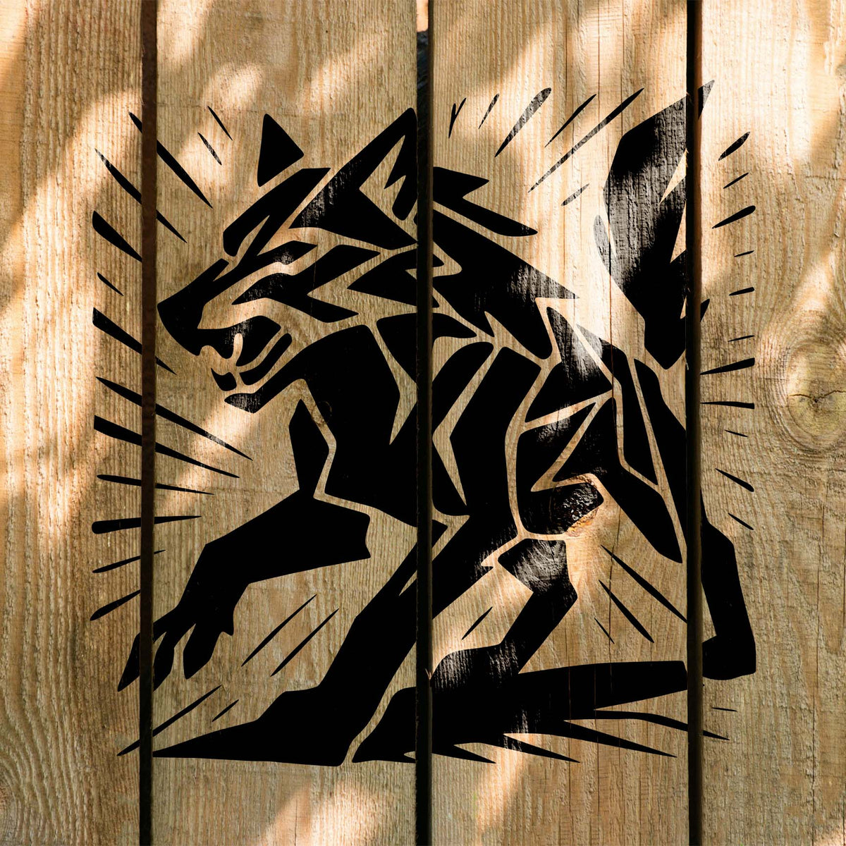 Across sunlit wooden planks, the Geometric Wolf Stencil shows a lunging wolf with angular details.