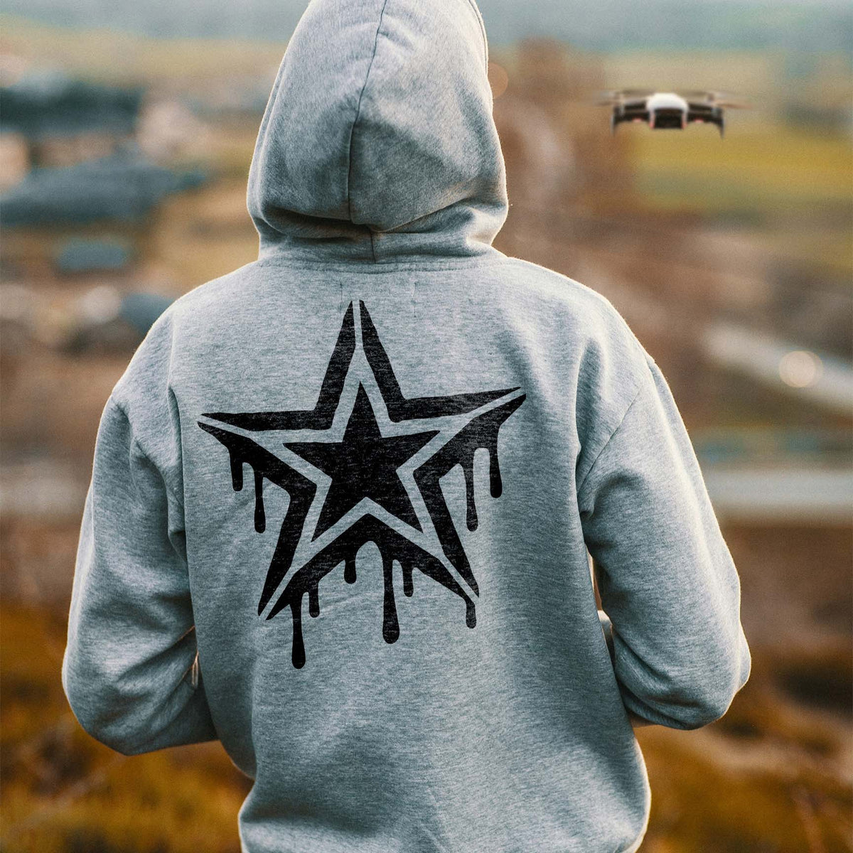 A gray hoodie features the Graffiti Drip Star Stencil in a striking black street-art design