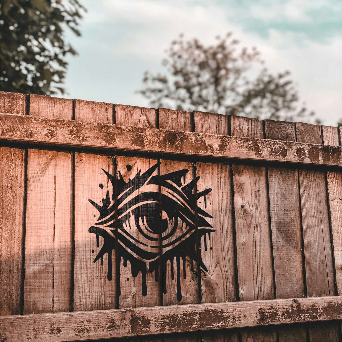 On a weathered fence, the Graffiti Eye Street Art Stencil creates a striking street art look.