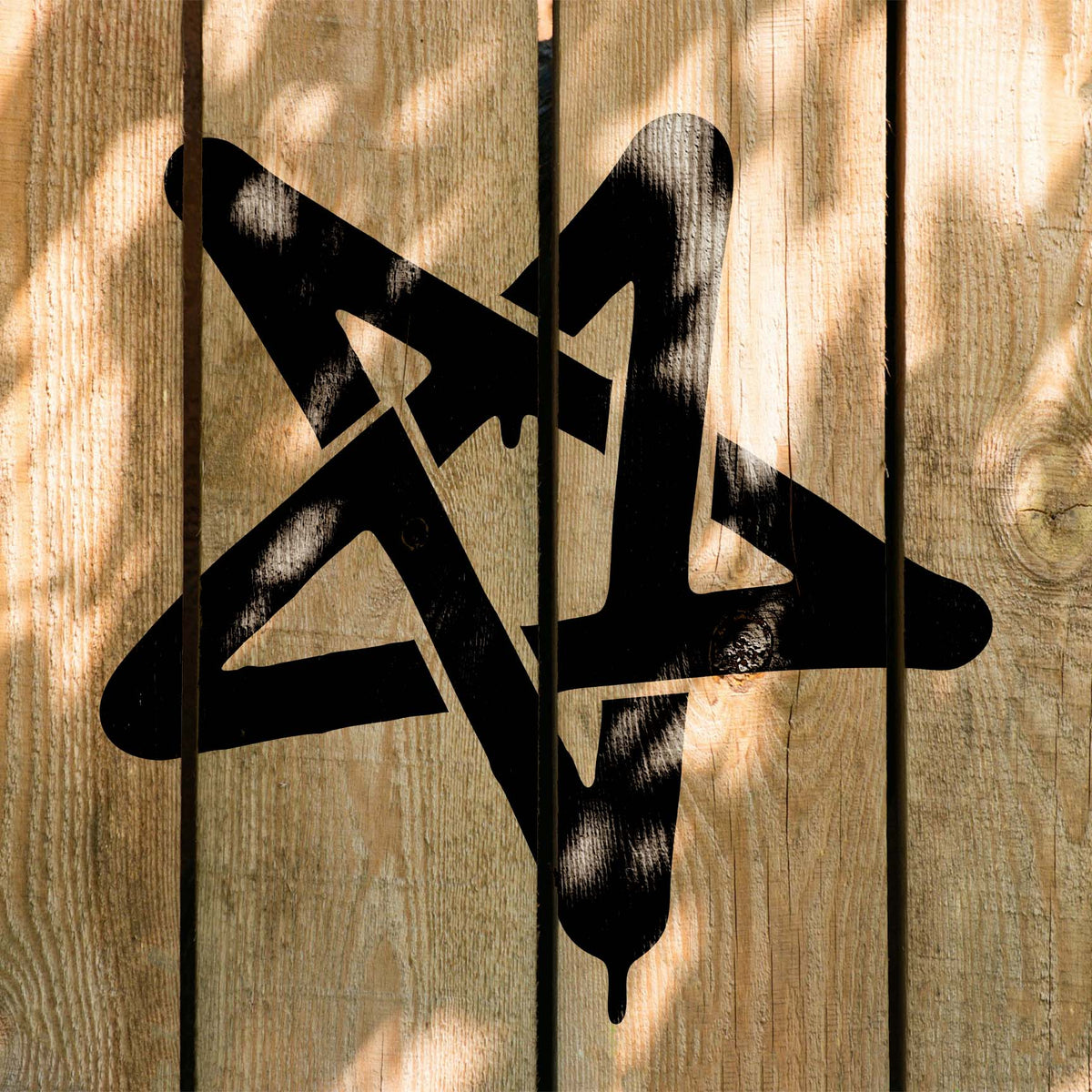 Sunlit wood planks display the Graffiti Star Stencil with a bold black finish