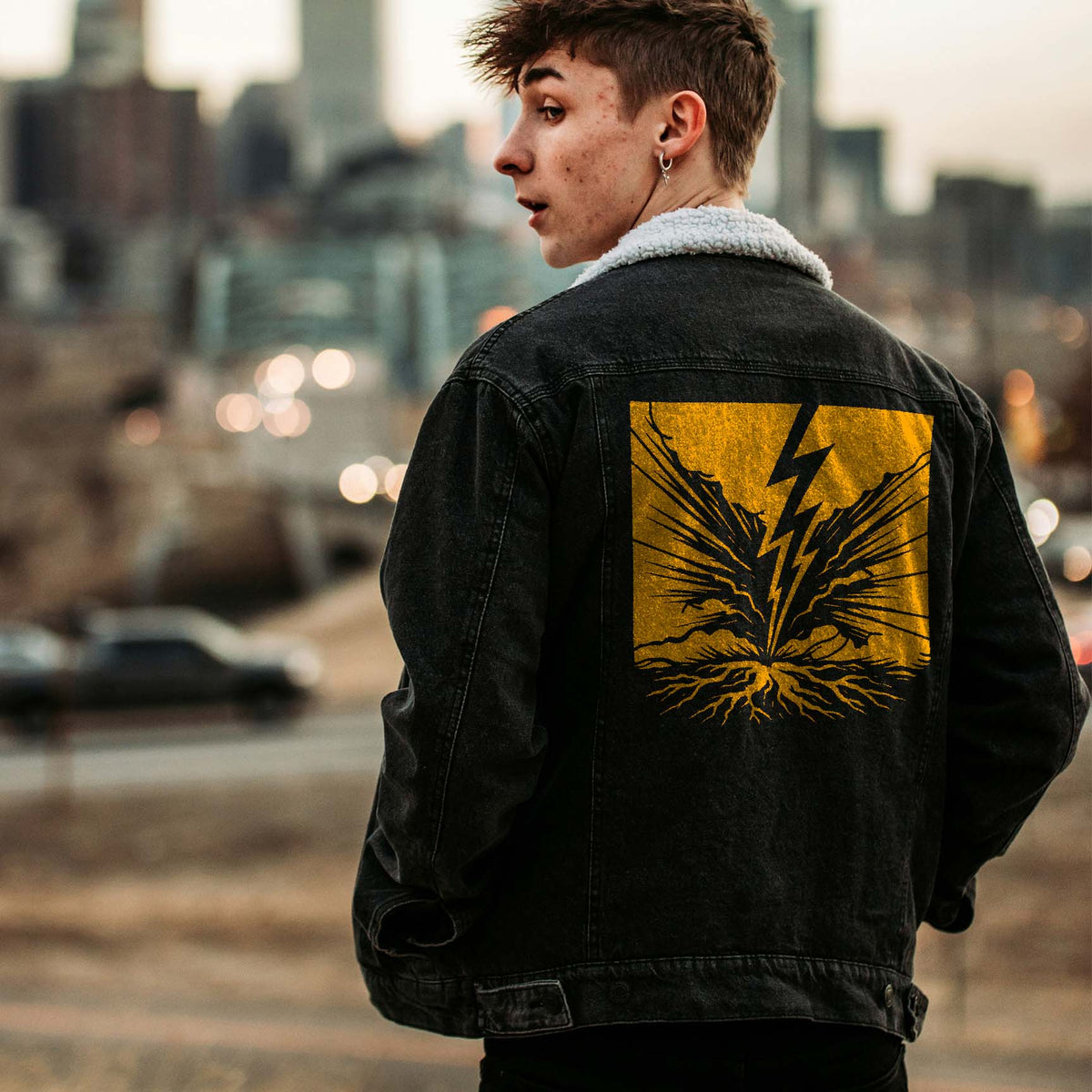Golden Ground Strike Lightning Stencil electrifies the back of a black denim jacket