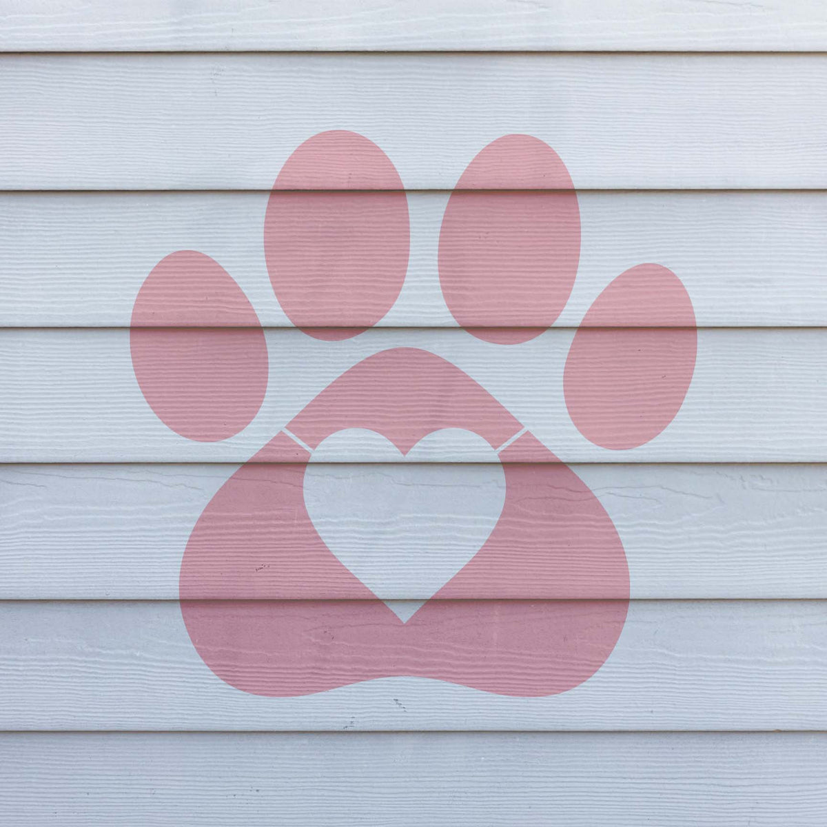 Heart Paw Print Silhouette Stencil in dusty pink stands out on clean white exterior siding