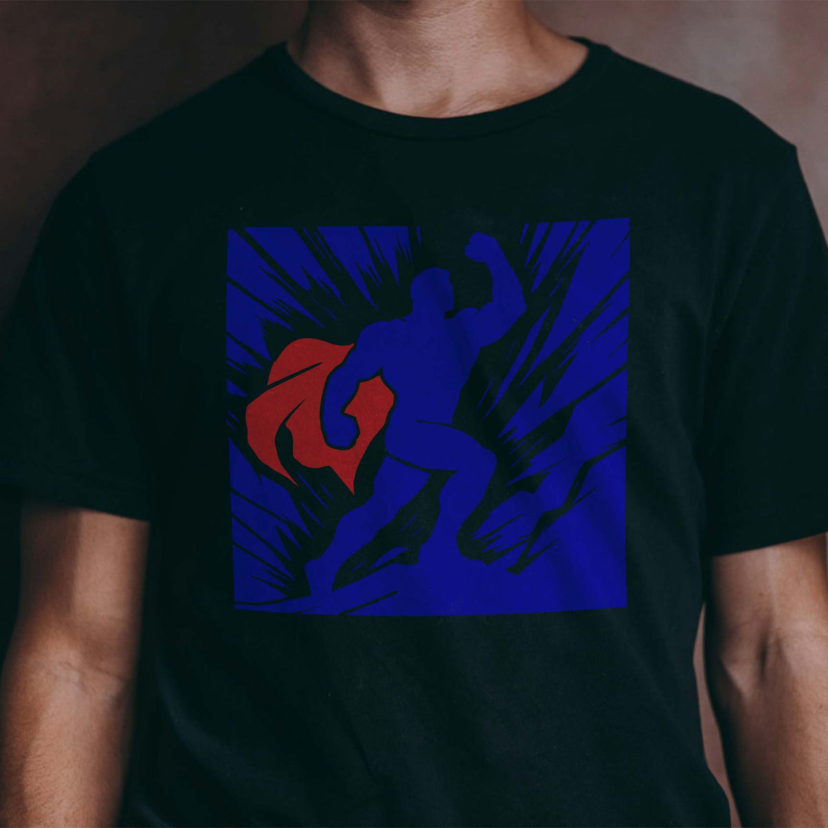 Heroic Superhero Silhouette Stencil powers forward in blue and red across a black T-shirt