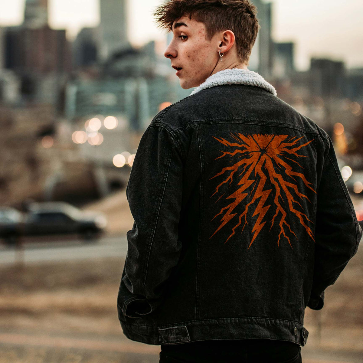 Bold orange Lightning Strike Burst Stencil electrifies the back of a black denim jacket