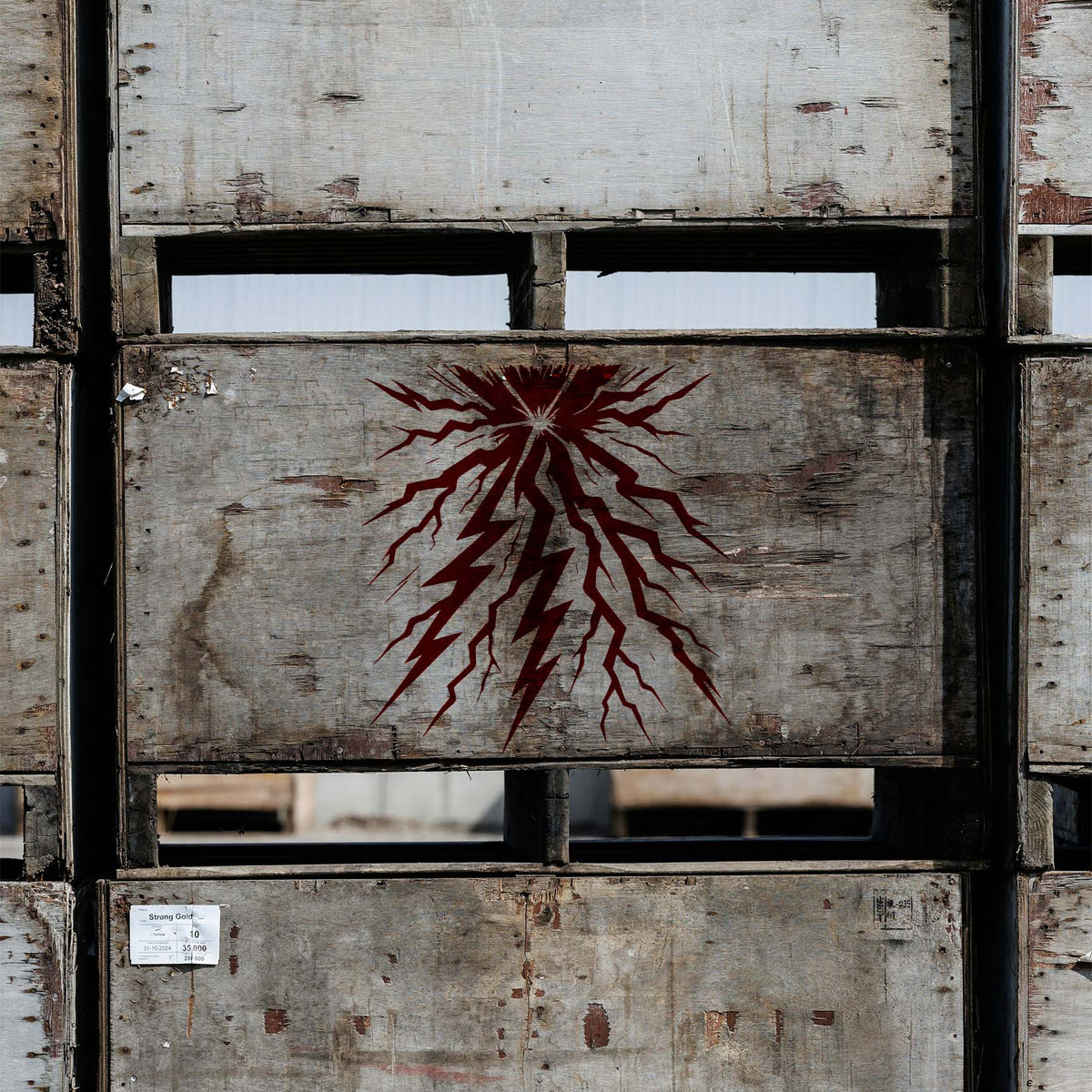 Lightning Strike Burst Stencil flashes in deep red across a weathered industrial wooden crate