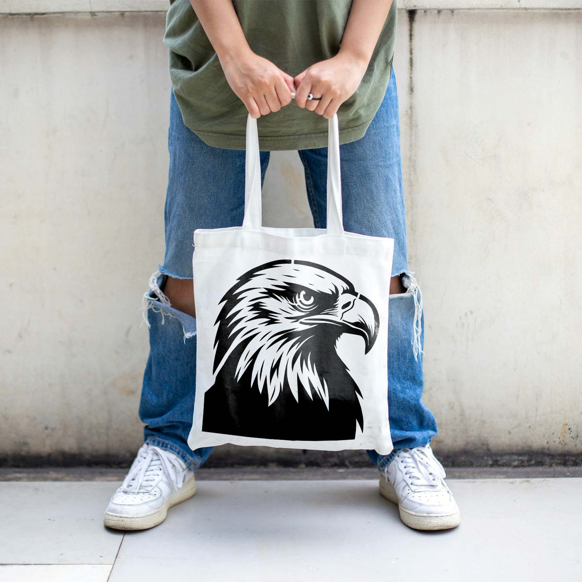 A white tote bag displays the Majestic Bald Eagle Head Stencil with striking feather details and a sharp gaze.