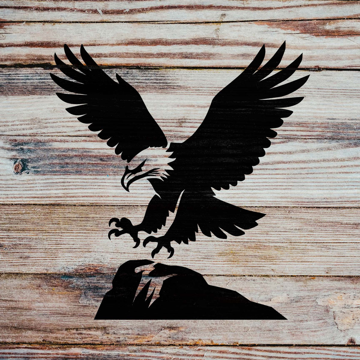 Across rustic wooden planks, the Majestic Eagle Landing Stencil captures an eagle swooping toward a rocky perch.