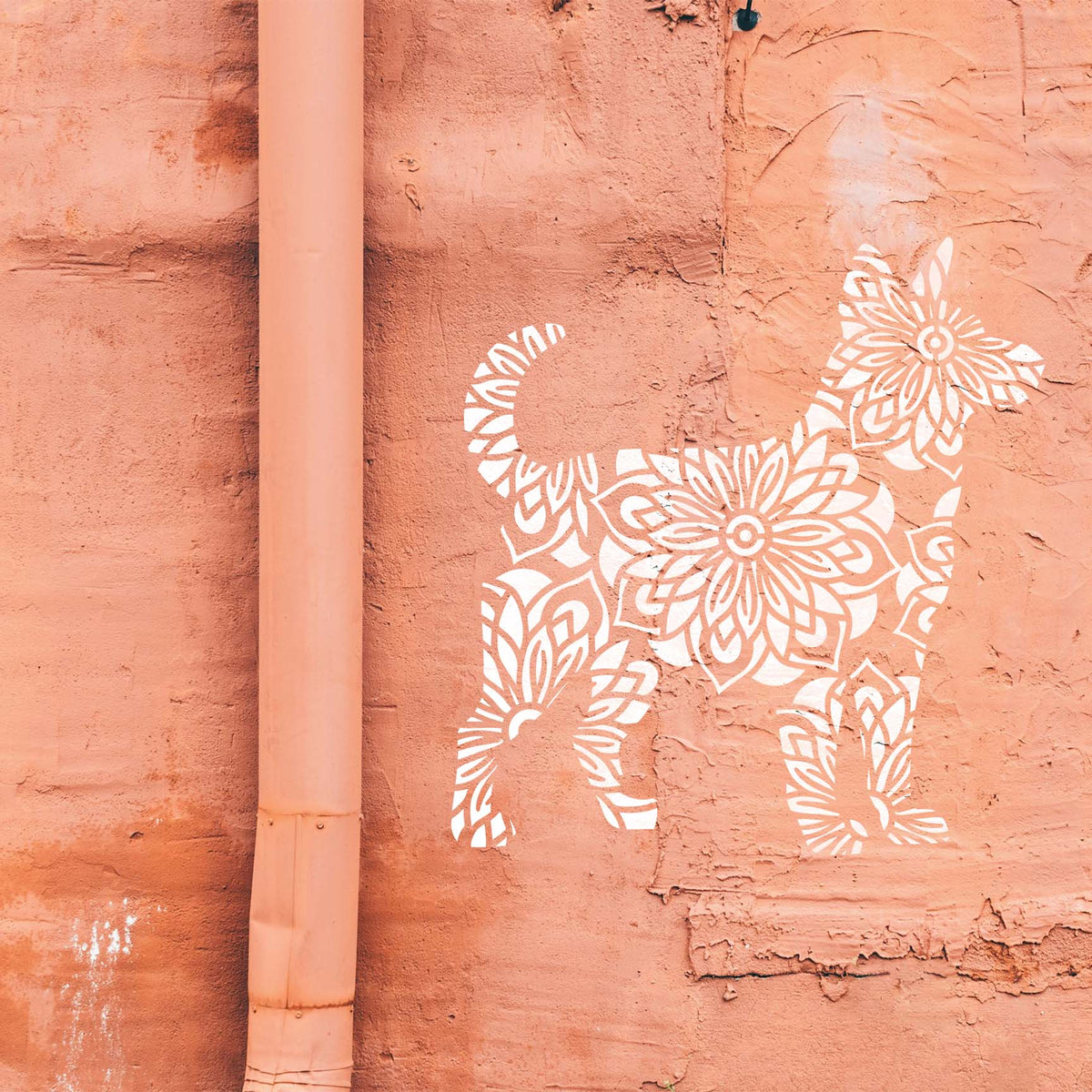 White Mandala Floral Dog Silhouette Stencil stands out across a weathered peach wall