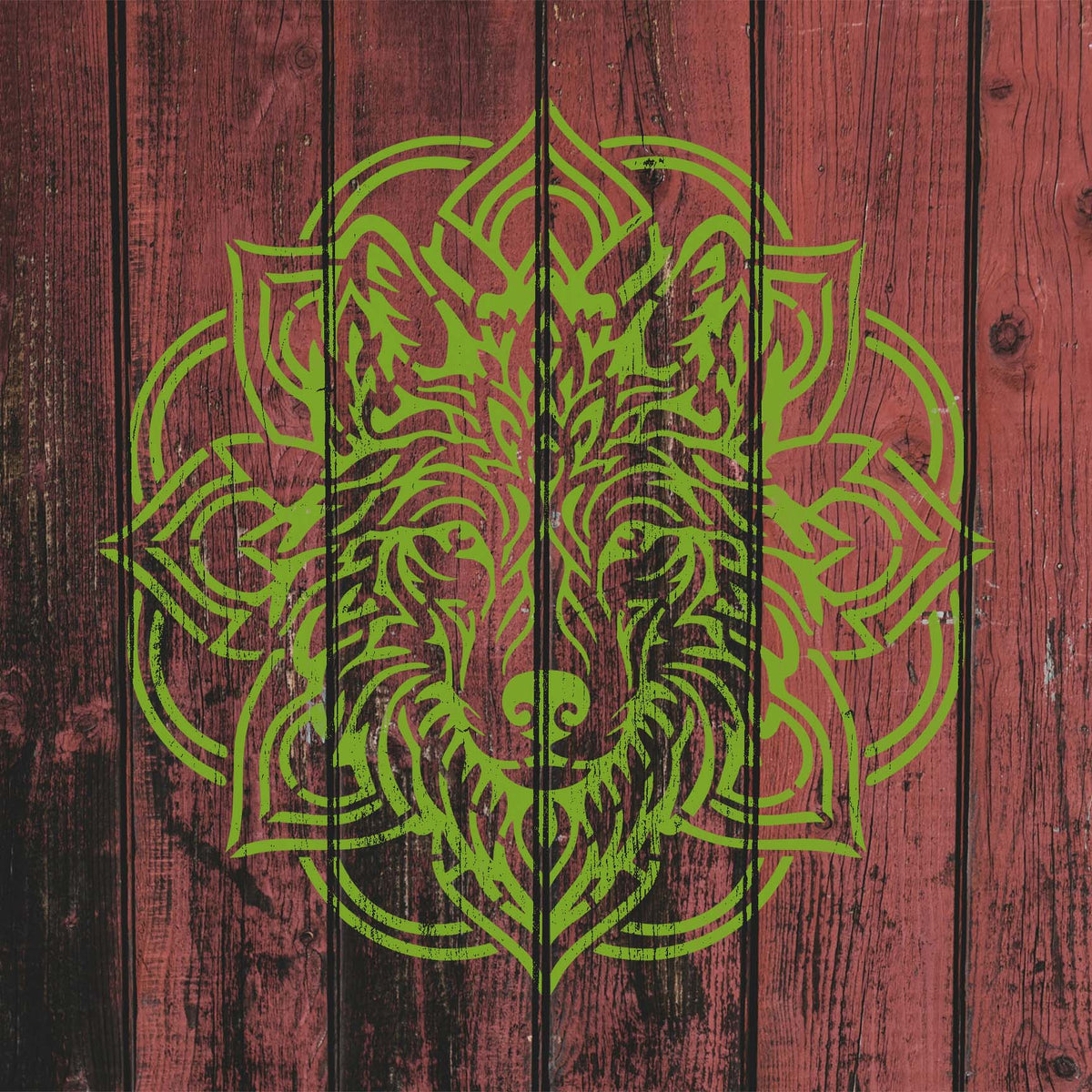Rustic red wood showcases the Mandala Wolf Head Stencil with an ornate green wolf design.