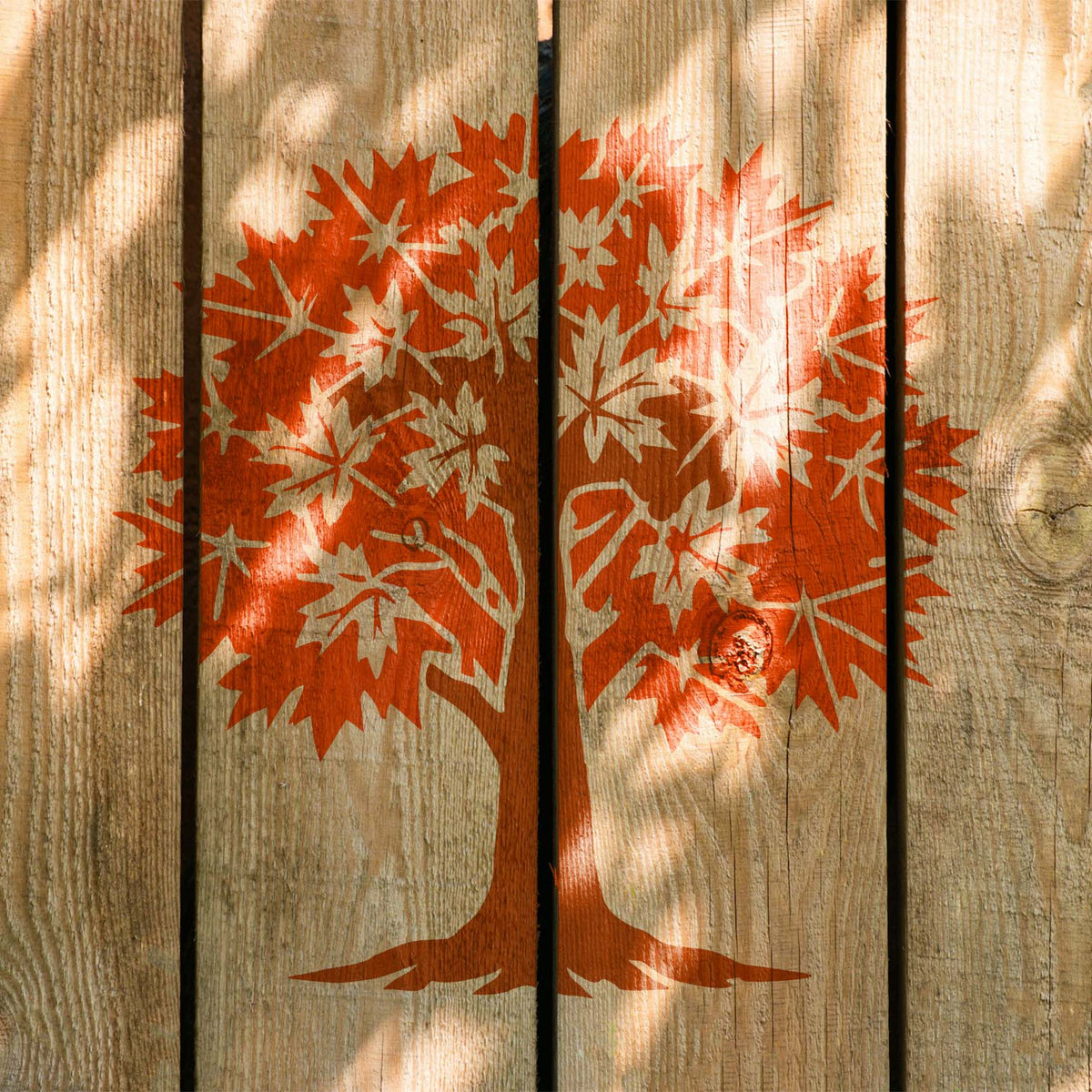 Maple Tree stencil with orange leaves painted across rustic wood planks