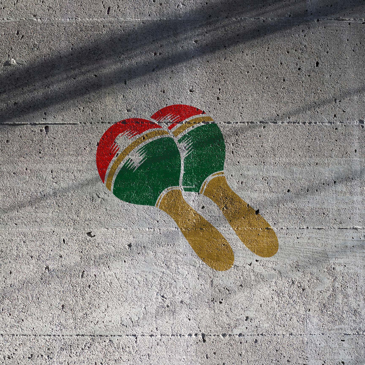 Maracas stencil with colorful paired instruments painted on concrete wall
