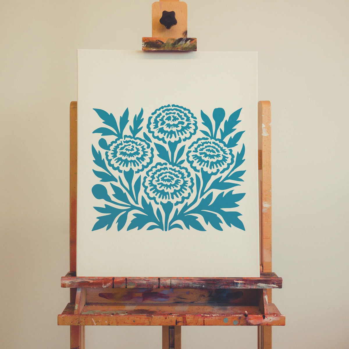 Marigold Flower Stencil displayed in blue on a white canvas set on a wooden easel.