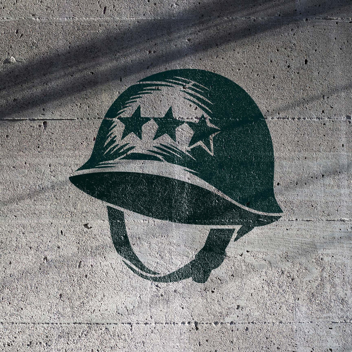Military Combat Helmet Stencil with three stars painted on a textured concrete wall.
