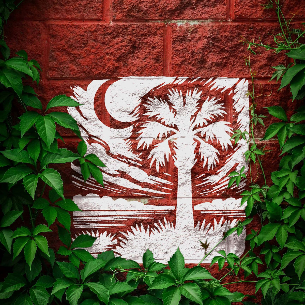 Moonlit Palmetto Landscape Stencil painted white on red brick with palm tree and crescent moon