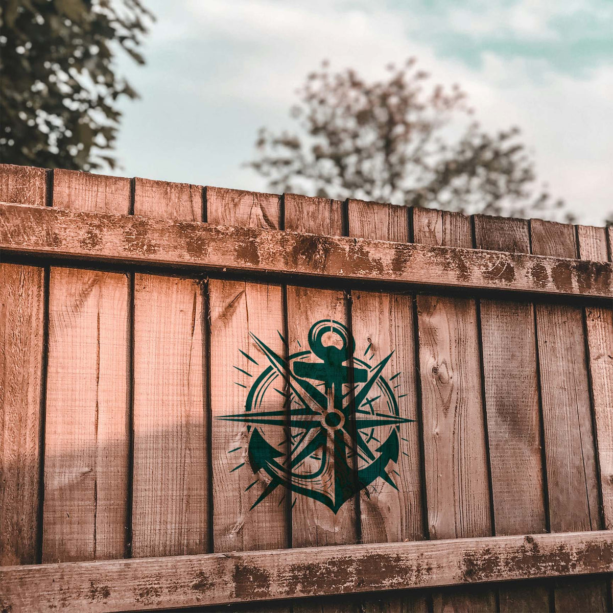 Rustic wood fence features the Nautical Anchor Compass Rose Stencil with anchor and compass points