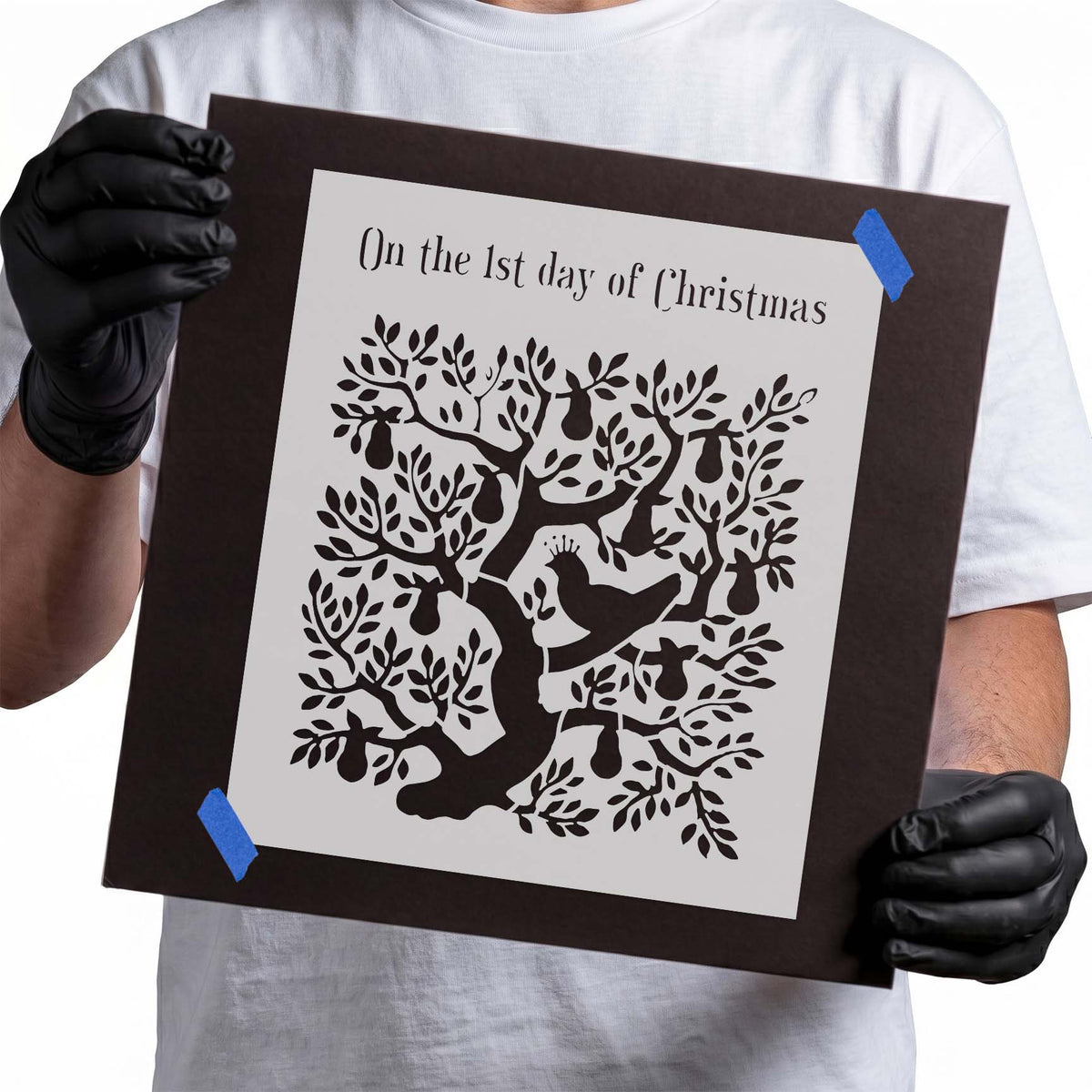 Partridge nestled among leafy pear tree branches in a Christmas stencil