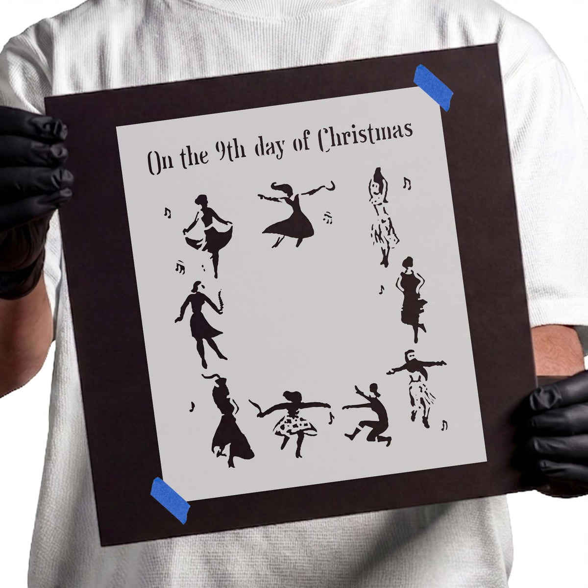 Christmas stencil with nine dancing silhouettes and scattered musical notes
