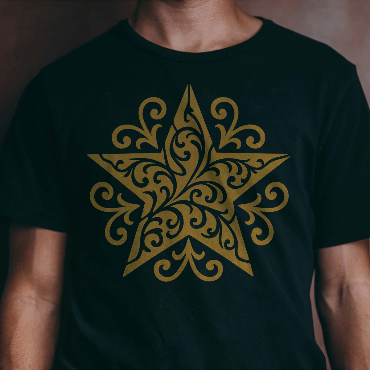 Golden Ornate Filigree Star Stencil stands out across the chest of a black T-shirt