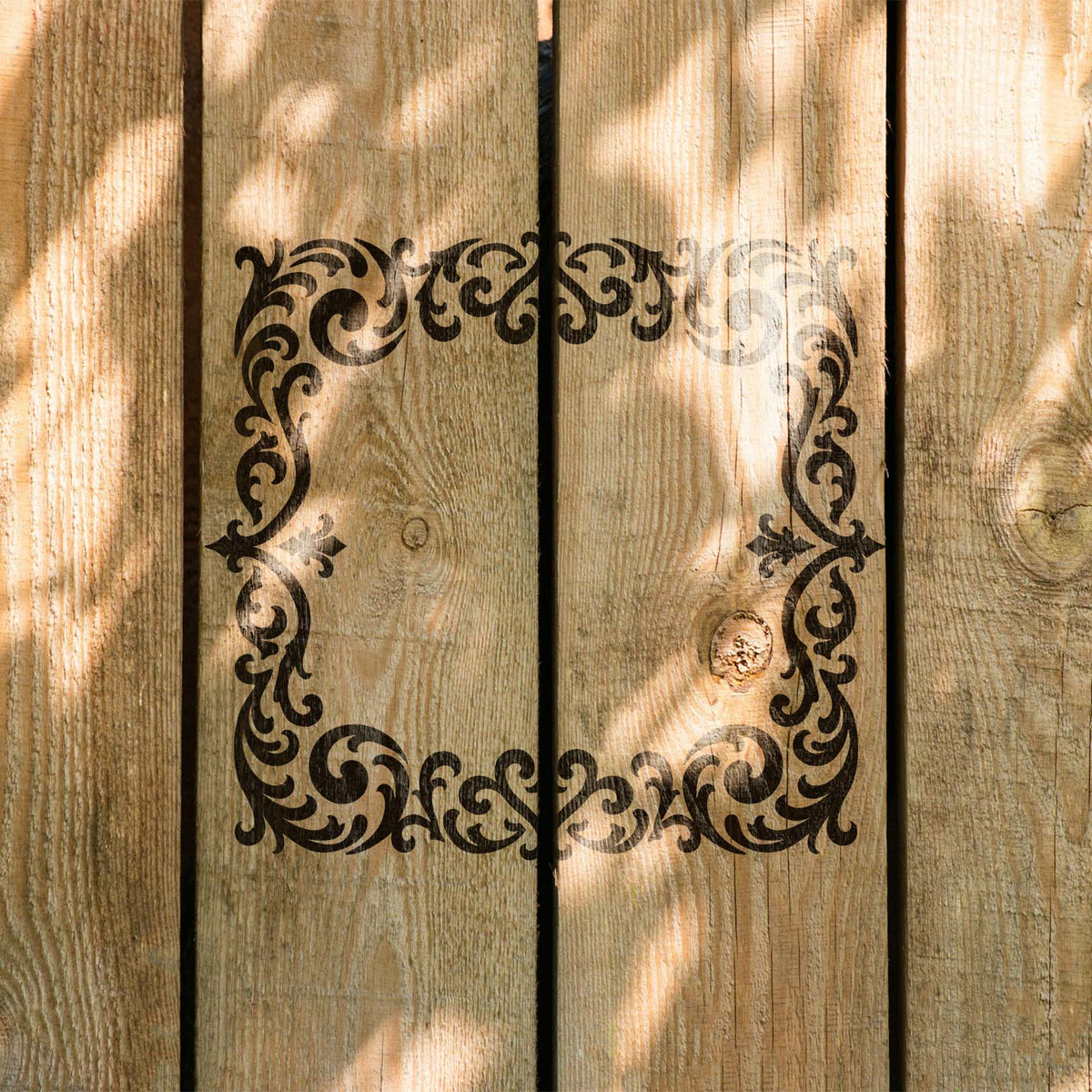 Rustic wood panels feature the Ornate Gothic Filigree Border Stencil in dark paint