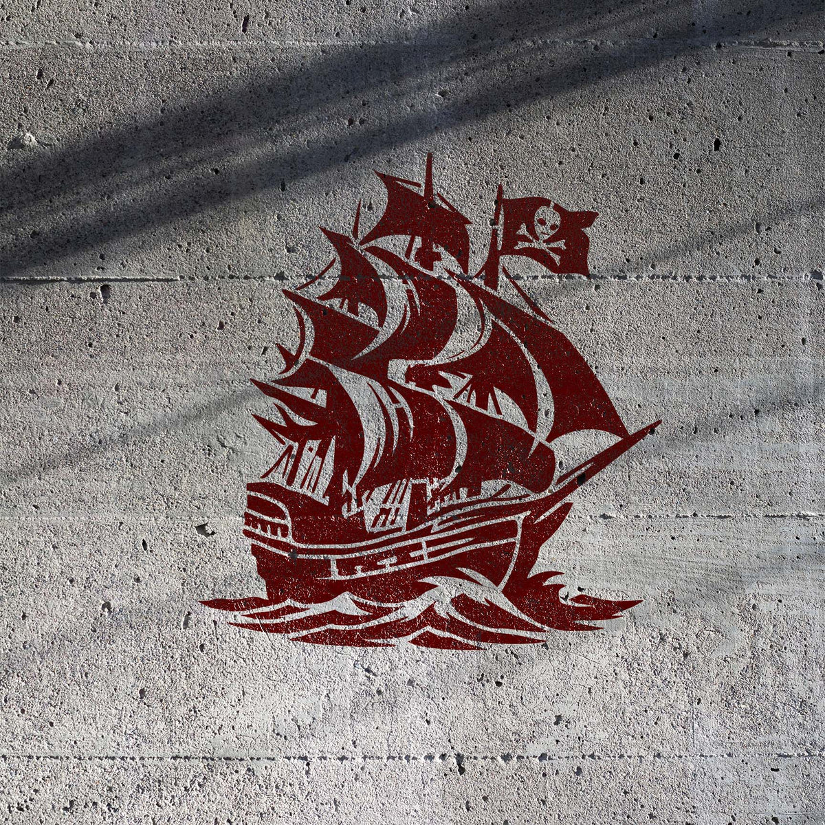 Skull Flag Pirate Ship stencil with sailing ship and skull flag on concrete