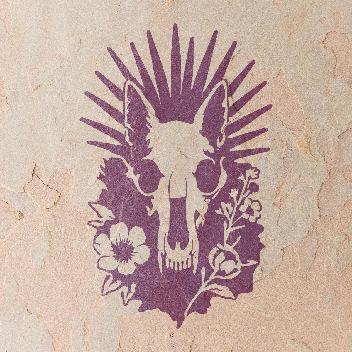 Radiant Animal Skull and Wildflower Stencil in purple on a rustic textured wall