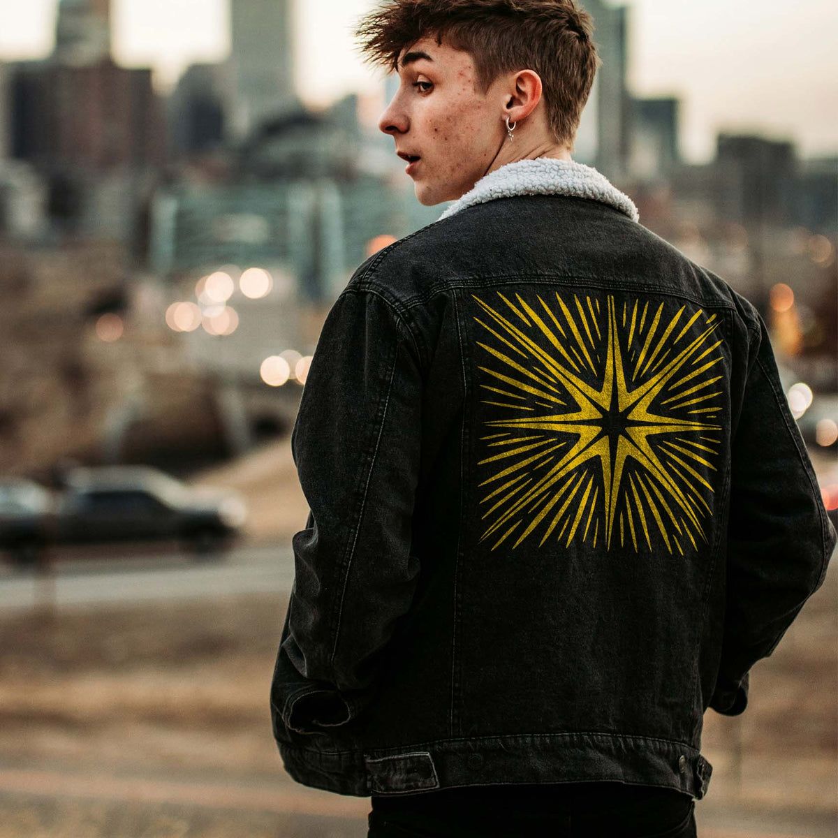 A black denim jacket showcases the Radiating Eight-Point Star Burst Stencil in bold golden rays
