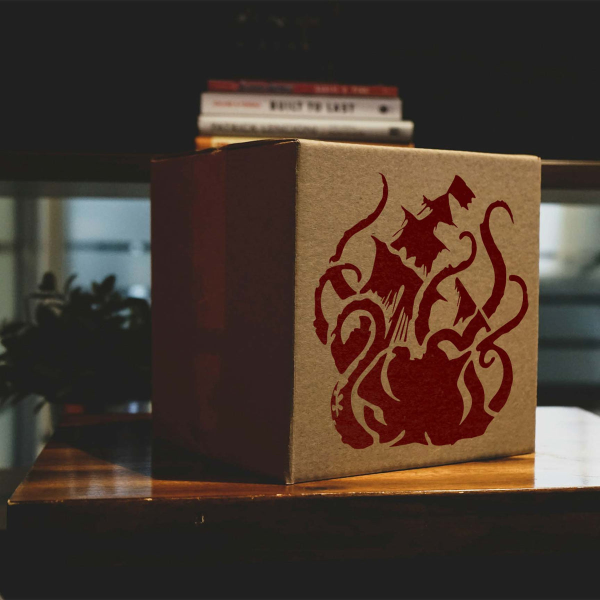 Sea Monster Attack Stencil painted in dark red across a kraft cardboard box