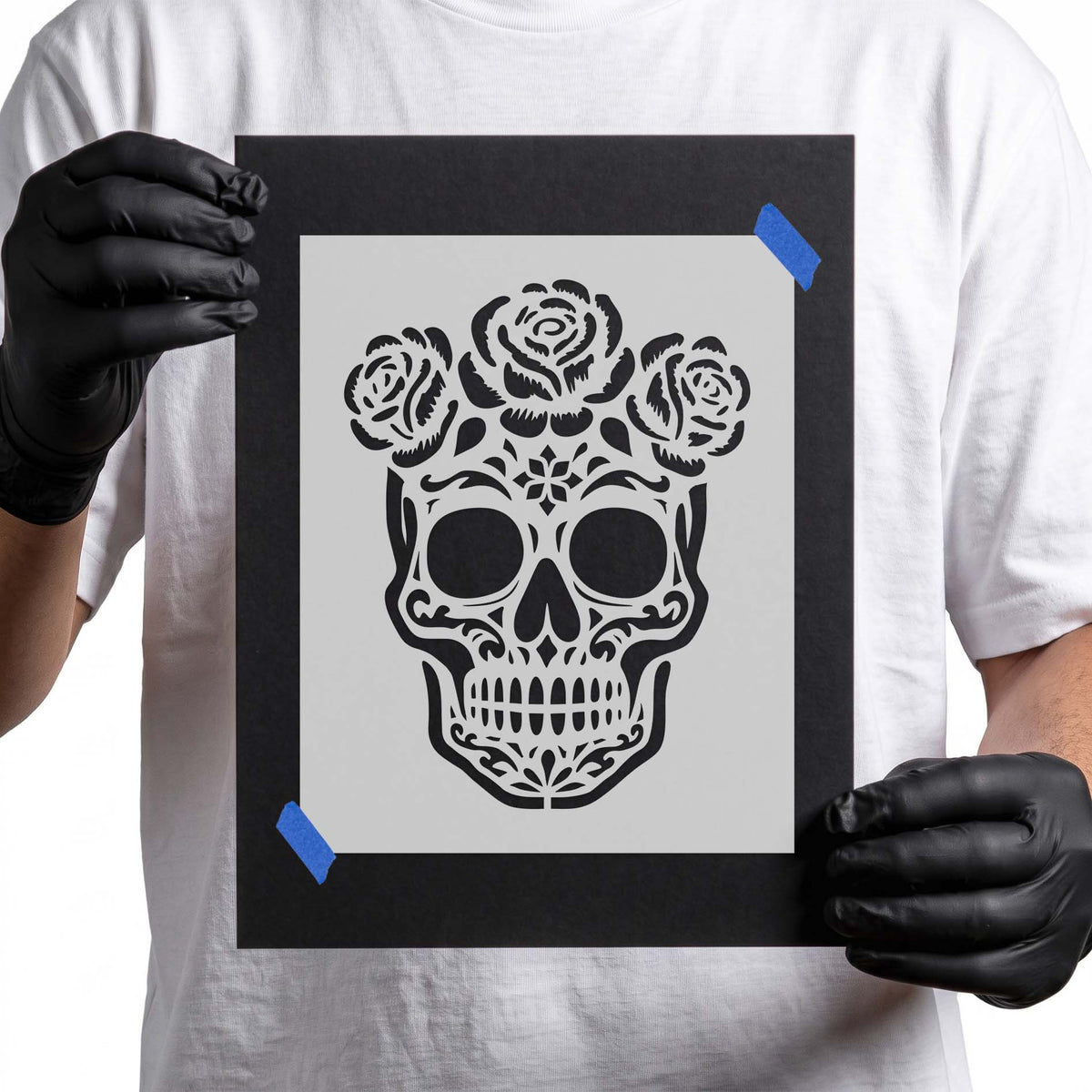 Decorative sugar skull stencil with three roses, hollow eyes, and intricate floral patterns